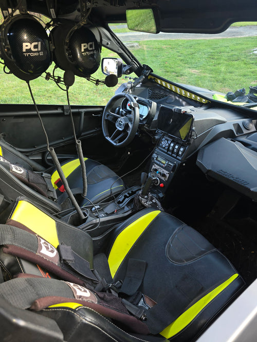 Interior of a side-by-side with black and yellow seats, dashboard, and steering wheel